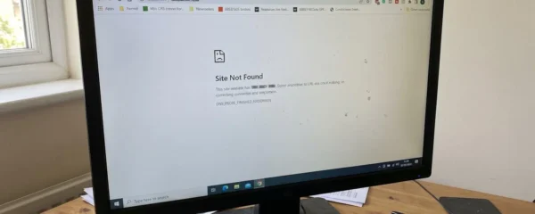 Gros plan sur des doigts tapant une adresse web sur le clavier rétroéclairé d'un ordinateur portable, avec un écran flouté en arrière-plan